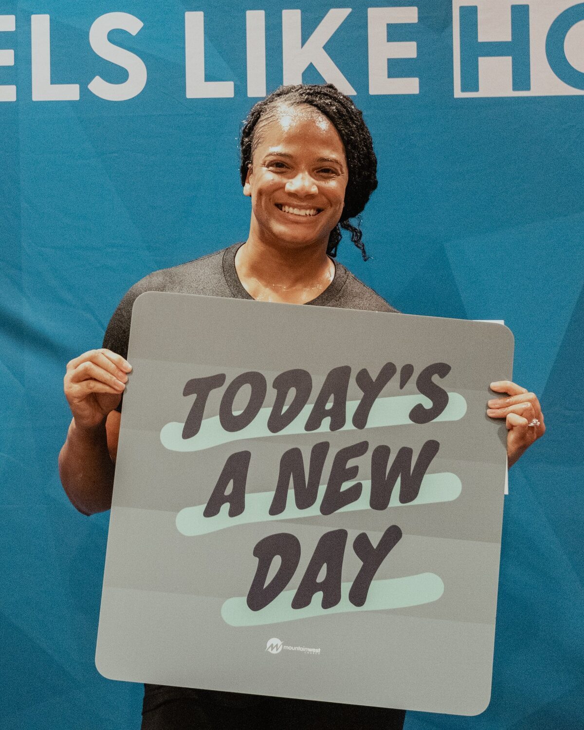 A woman holding a sign reading Today’s a new day