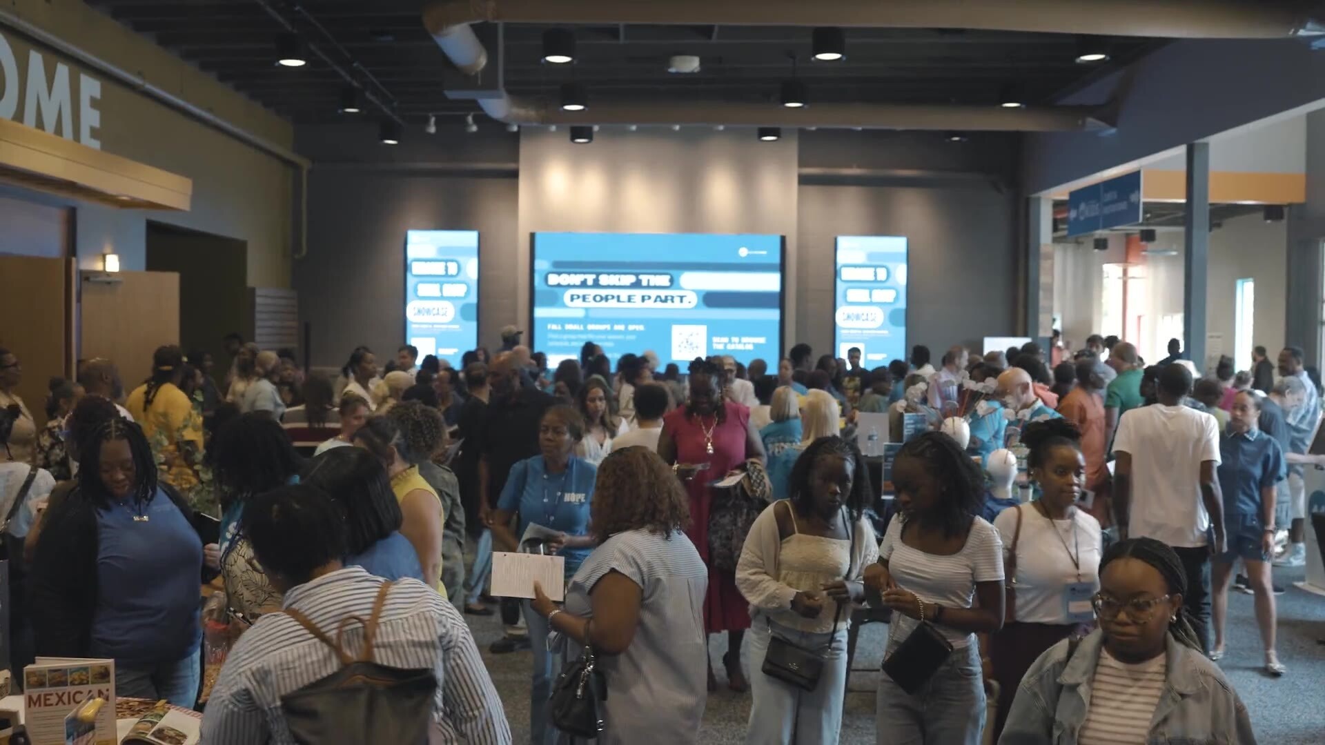 The lobby packed with people visiting small group tables at the Small Group Showcase