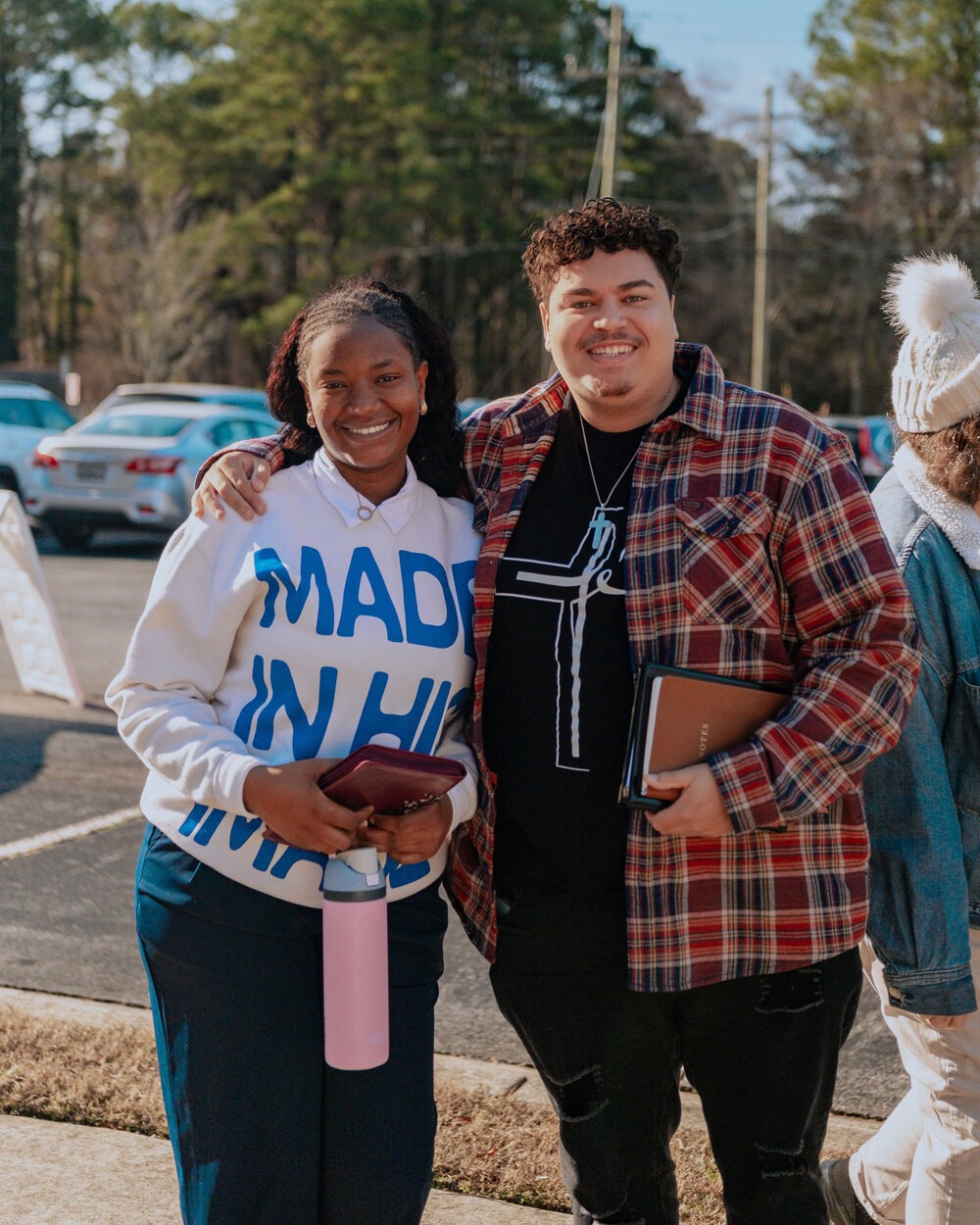 Two guests smiling together with their Bibles outside the Chamblee campus on a Sunday morning