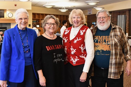 Four seniors smiling at the camera at a St. John's seniors event