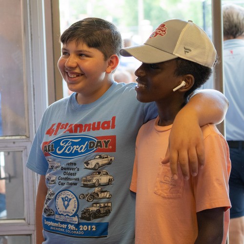 Two teenage boys with their arms over each other's shoulders