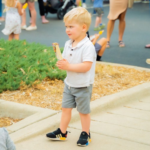 Child walking outside with a popsicle