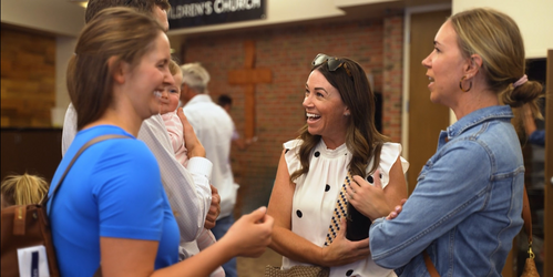 Group of women talking at a table at a women's conference