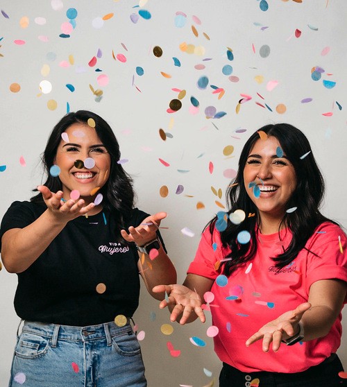 Dos mujeres celebrando con confeti