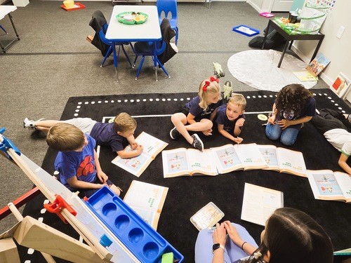 Students working on a rug in the classrom