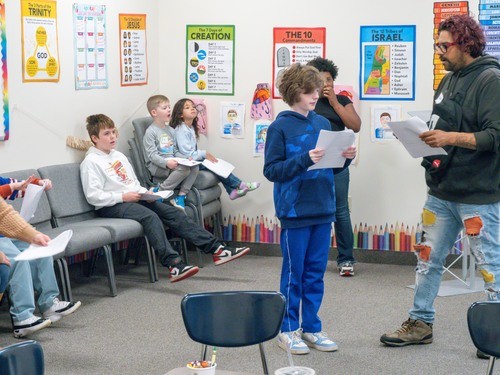 Kids rehearsing for a play in kidzone with a teacher