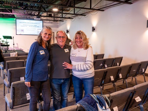 Picture of 2 women and a man smiling in the sanctuary during time of fellowship