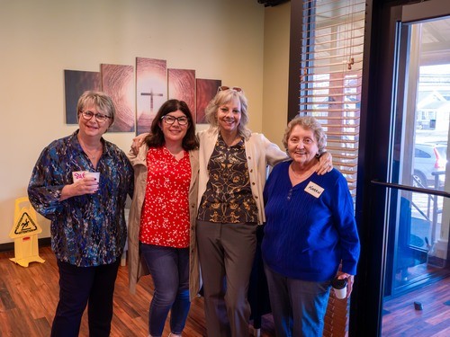 Picture of 4 women mingling in the lobby before service.