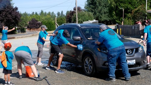 A group of kids weeding as part of a community outreach project