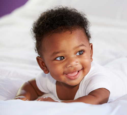 Baby laying on his belly smiling