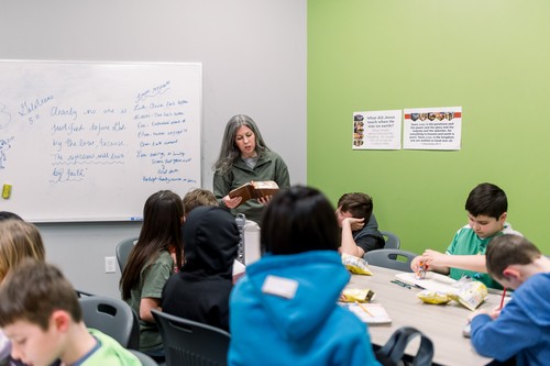 3 elementary school age girls arm in arm smiling at first redeemer children's church