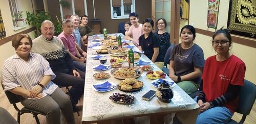 Larry Aultman from First Redeemer Church sitting a a dinner table with members of the Redeemer Church in Novosibirsk Russia