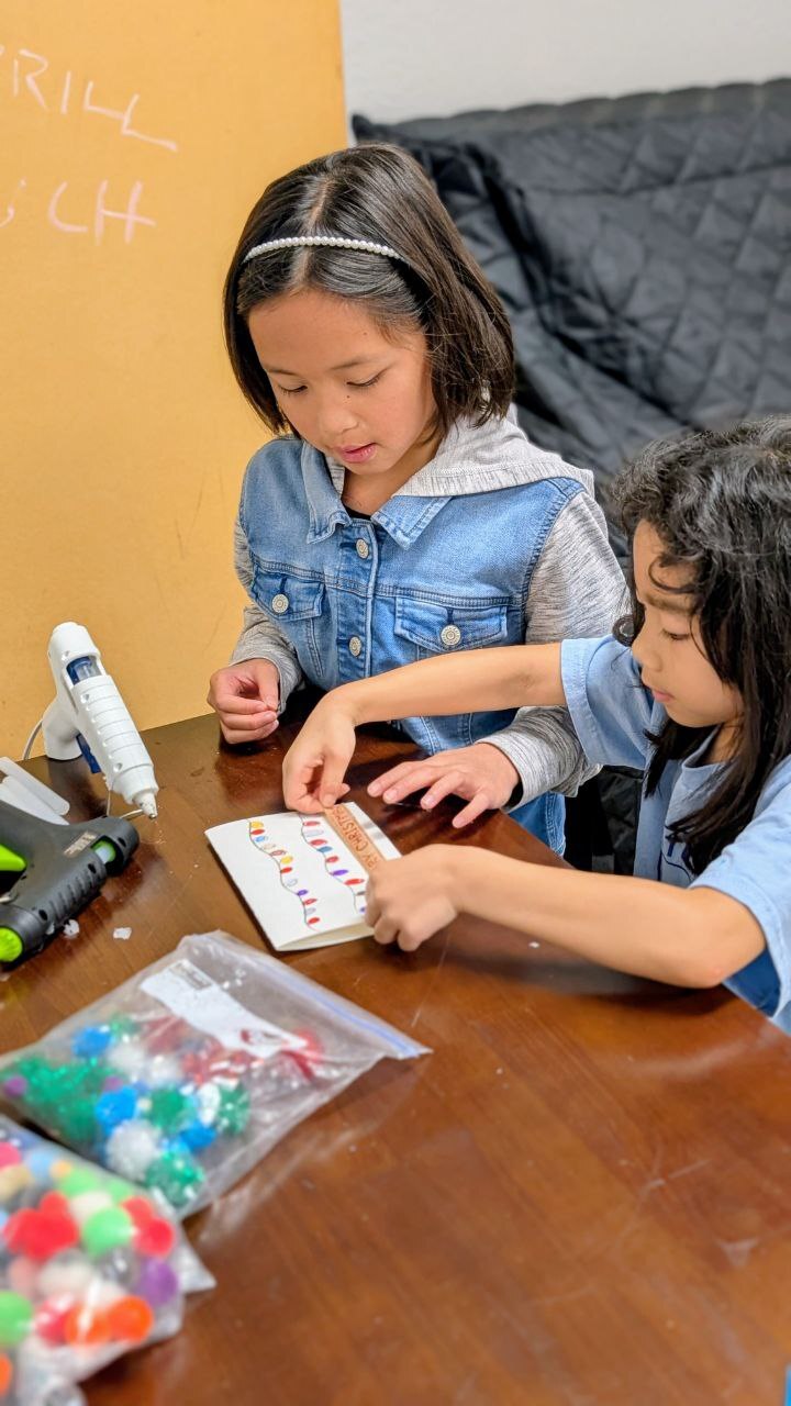 Group of children laughing while planting a tree together
